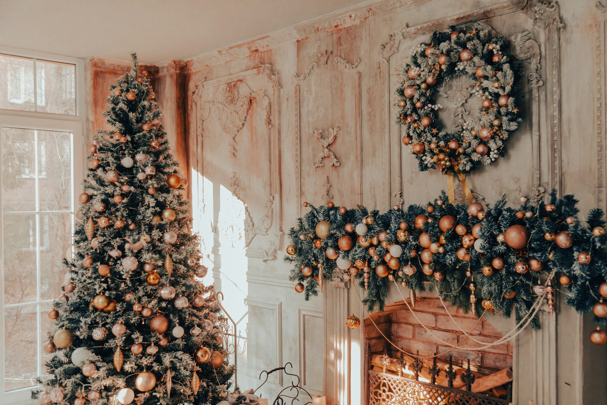 Living room decorated for Christmas with a tree and a garland over the fireplace